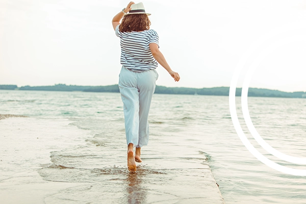 Woman walking on the beach to illustrate our weight loss program