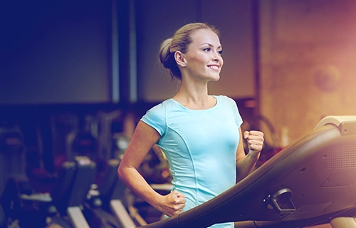 Woman on a treadmill smiling and healthy in grayscale