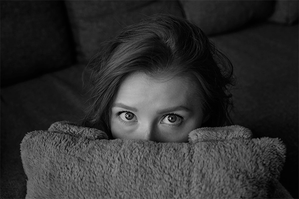 Woman hiding behind a blank to illustrate the fear and shame of extra weight